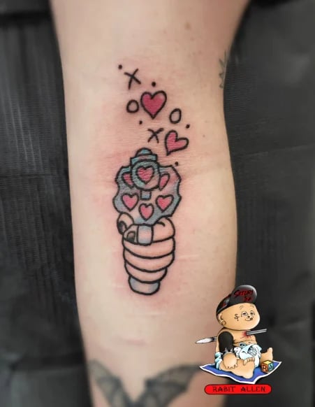 Tattoo on leg showing an ice cream cone with stacked red hearts and floating hearts with stars around it